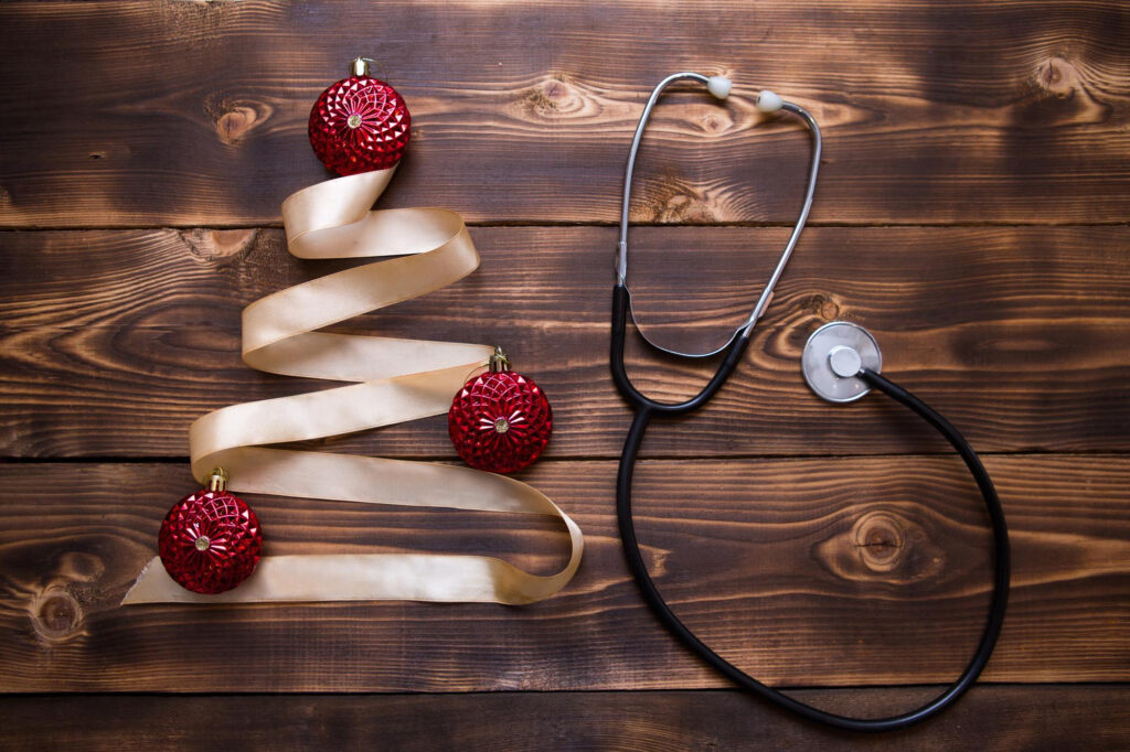 Bild eines Weinachtsbaum gelegt iin Seidenband und einem Stethoskop ald Dekoration daneben